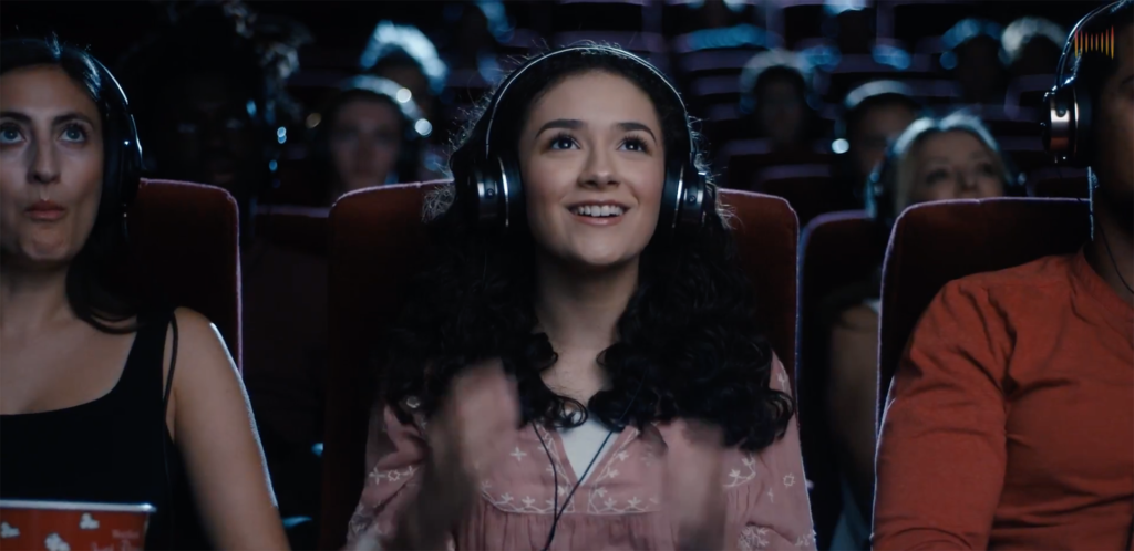 SoundFi™ delivers headphone-dedicated spatial sound to a girl in a theatre