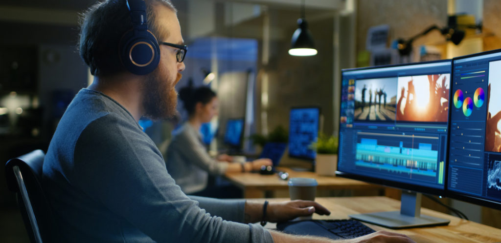 Videographers Edit and Cut Footage and Sound on Computer Monitors in Creative Studio.