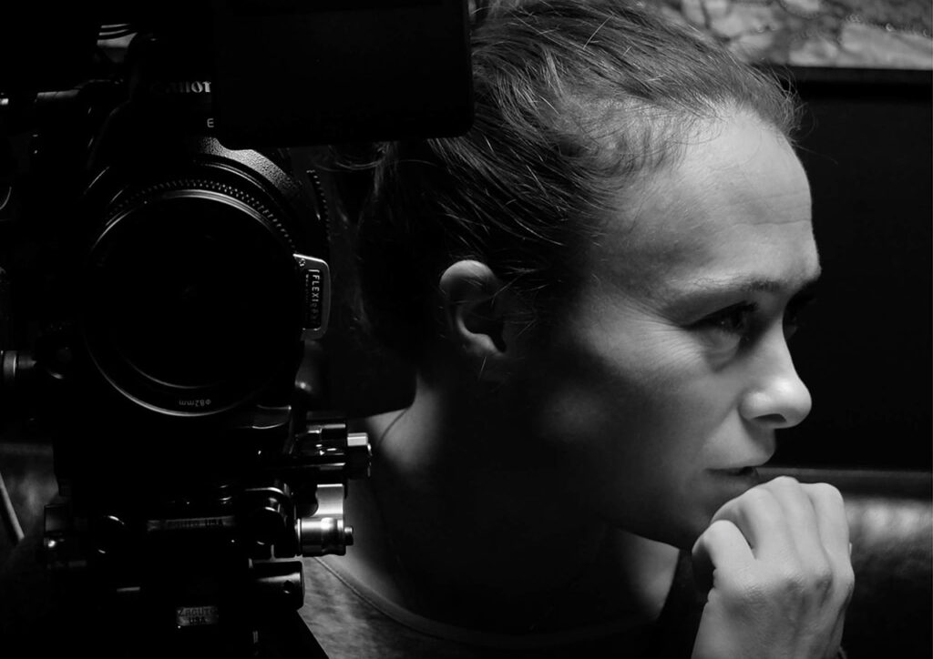 Caroline Bridges profile with Camera in black and white