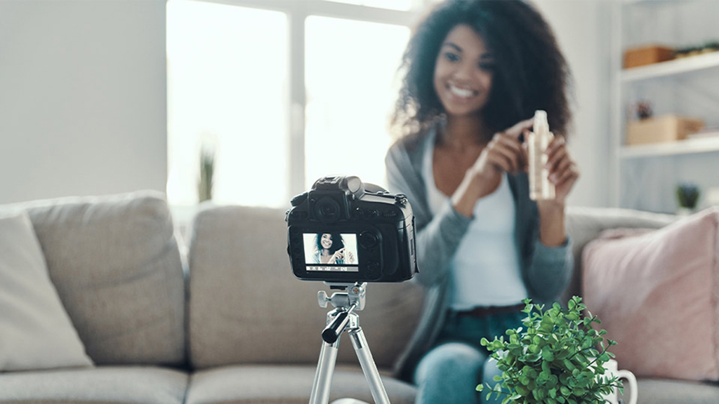 Woman films herself sitting on couch with product in hand
