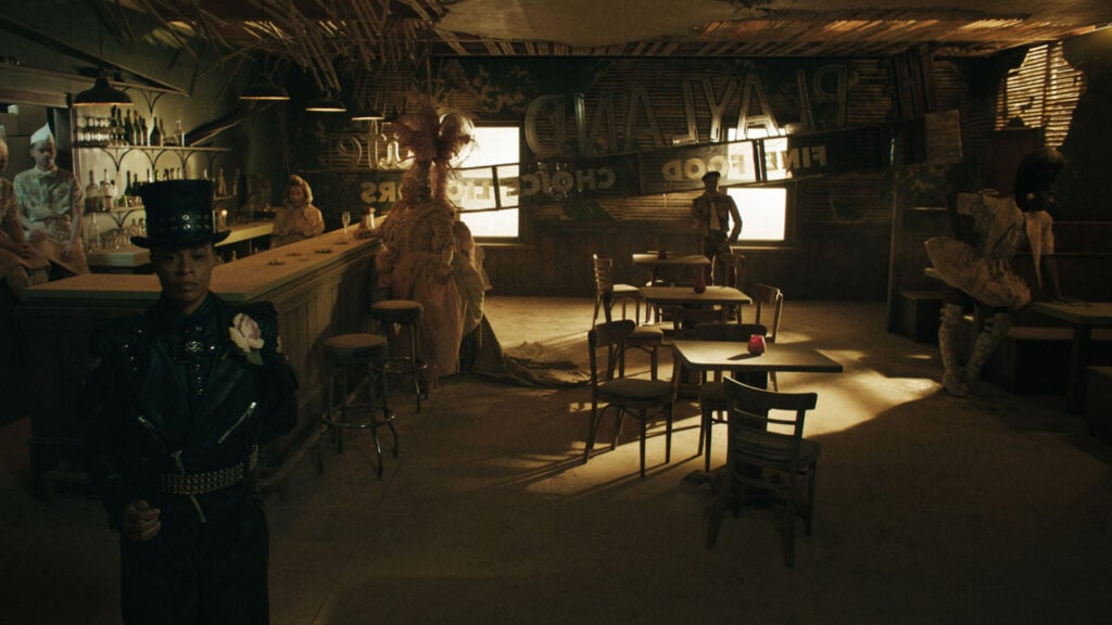 Playland scene featuring an LGBTQIA+ venue with costumed customers