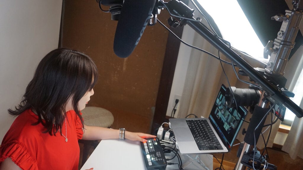 YouTuber amity_sensei in her studio with camera, Blackmagic ATEM Switcher, and MacBook computer