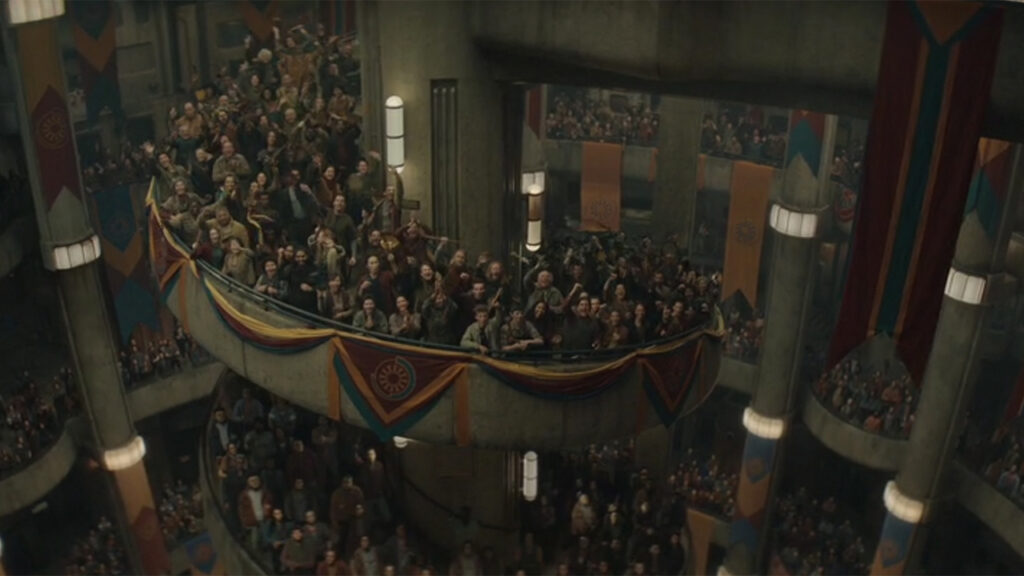 Scene from Silo with multitudes of people gathered inside a castle