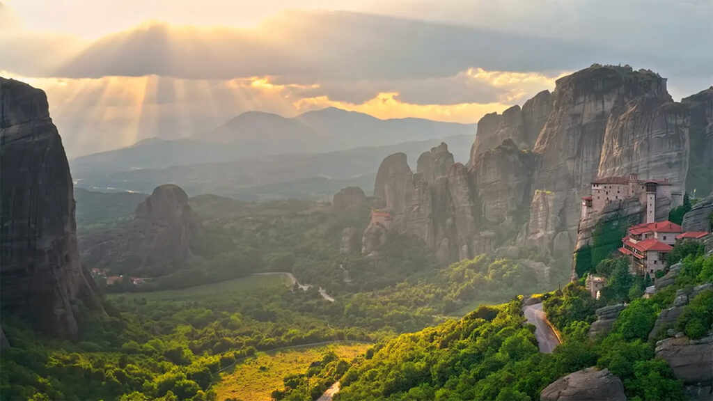 Mountain community on a hillside with sun shining down out of clouds credit: Adobe Stock/ Banana Republic