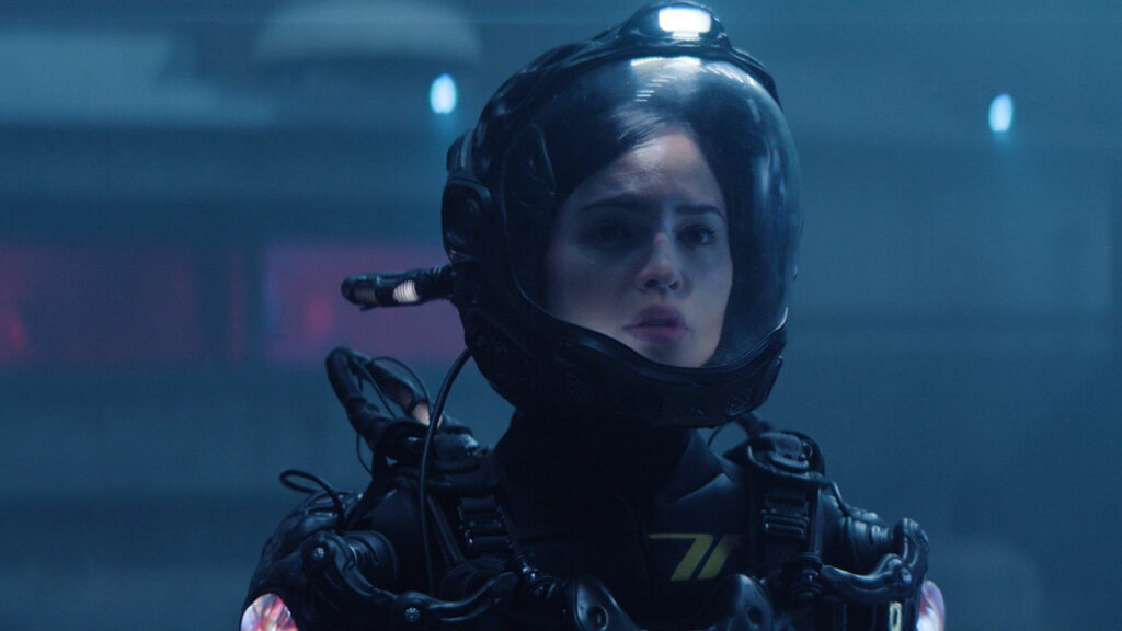 A woman stands in a spacesuit