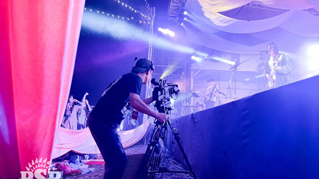 A man films a music concert with a Blackmagic camera