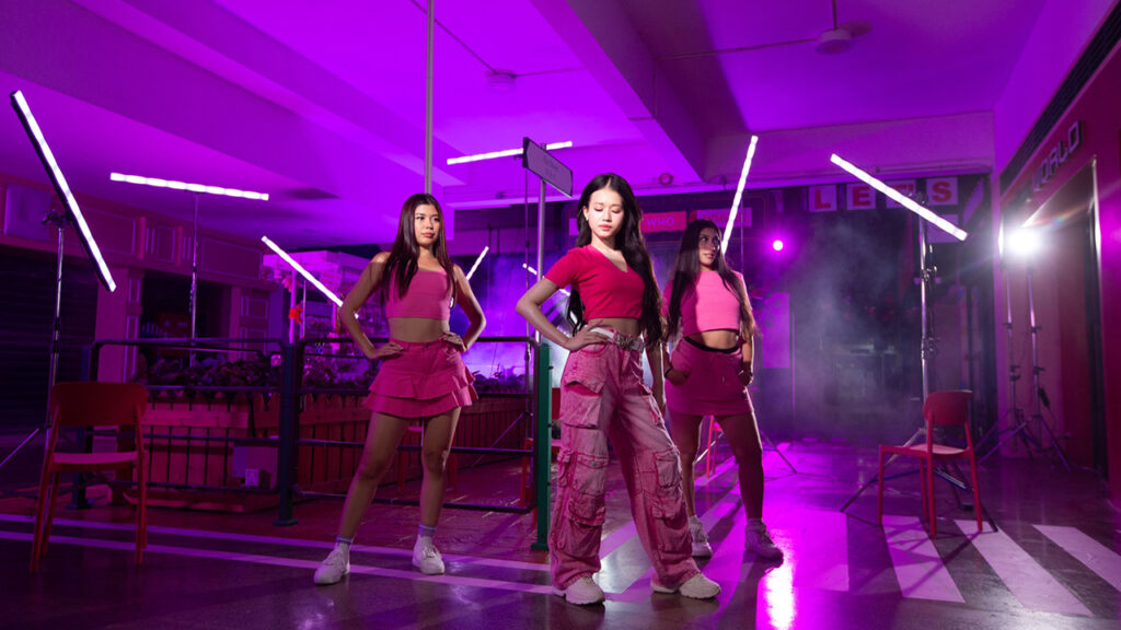 three girls wearing all pink pose in a studio