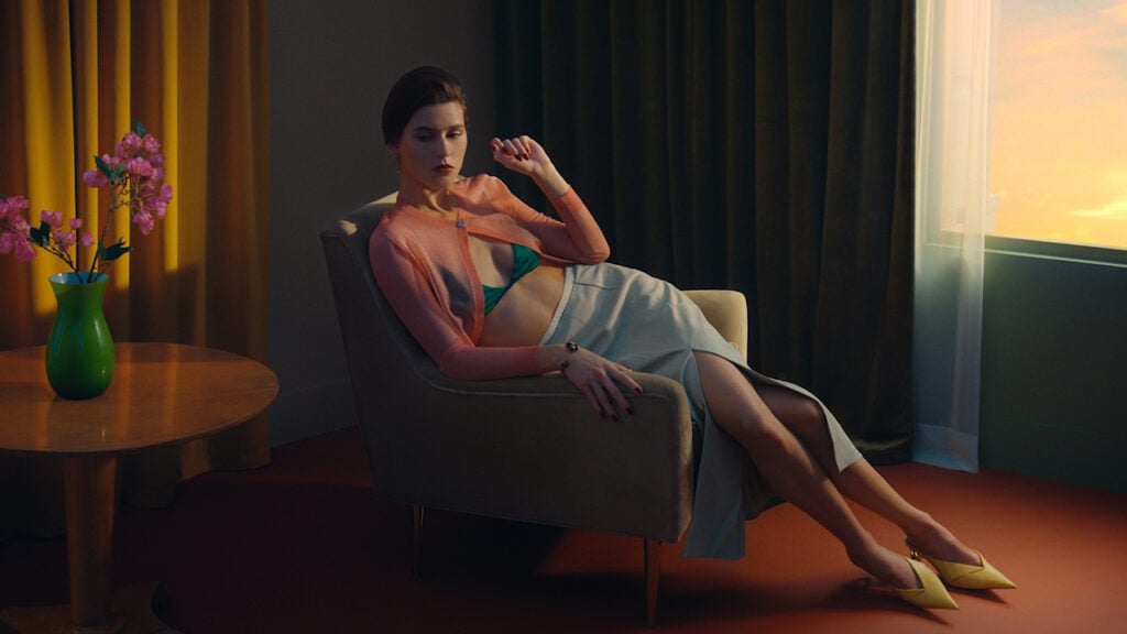 a scene from a commercial by Tim Masick featuring a woman lounging on a chair