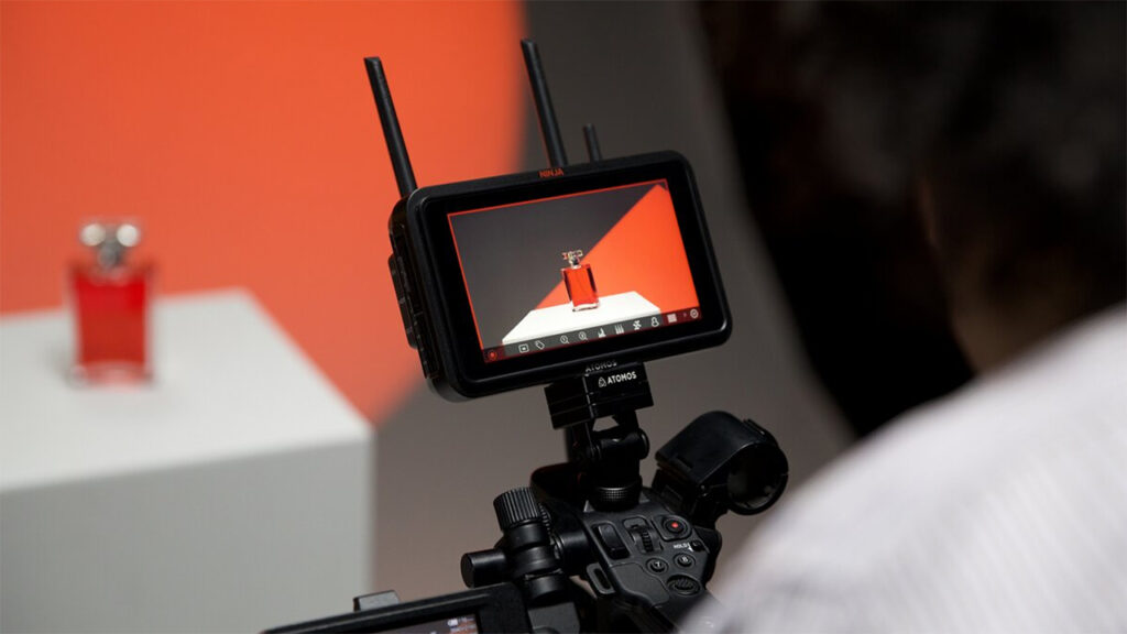 a person views footage of a bottle of perfume through an Atomos monitor