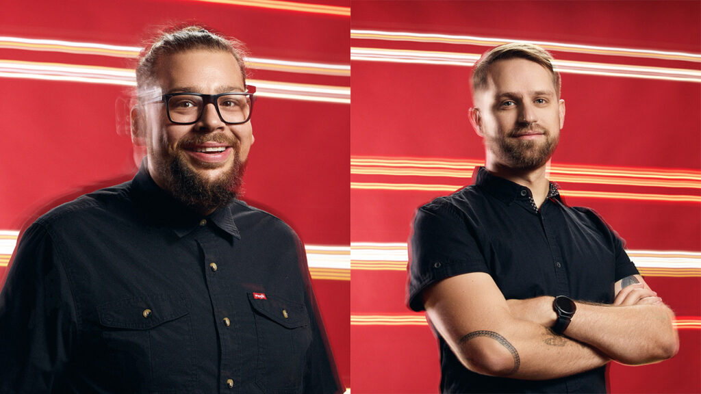 OddBeast Executive Director Tj Bitter and OddBeast Executive Producer Michael Brookbank stand in front of a red background