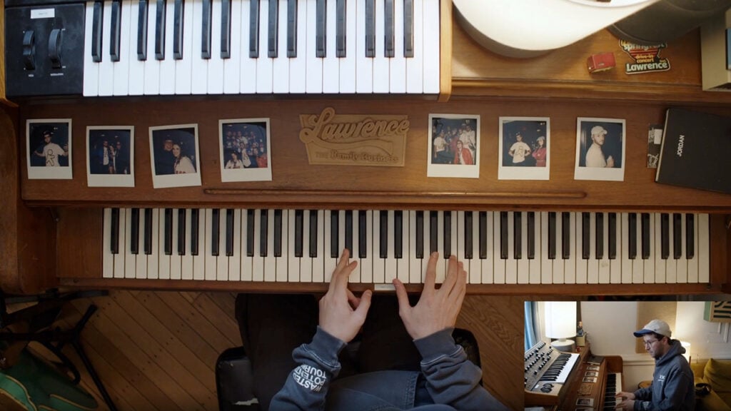 A person's fingers rest on the keys of a piano