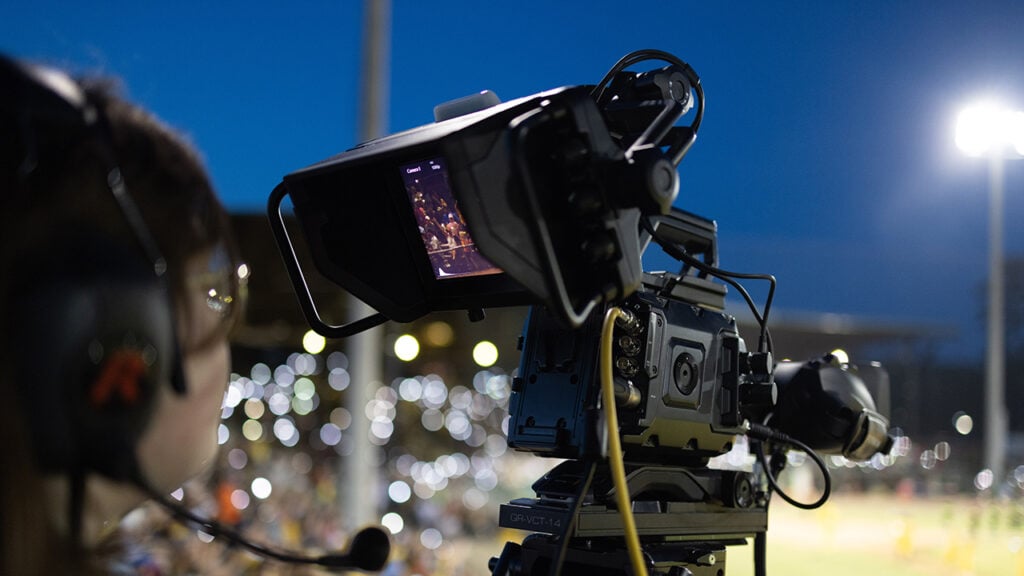 a person runs a Blackmagic camera to film a sports event