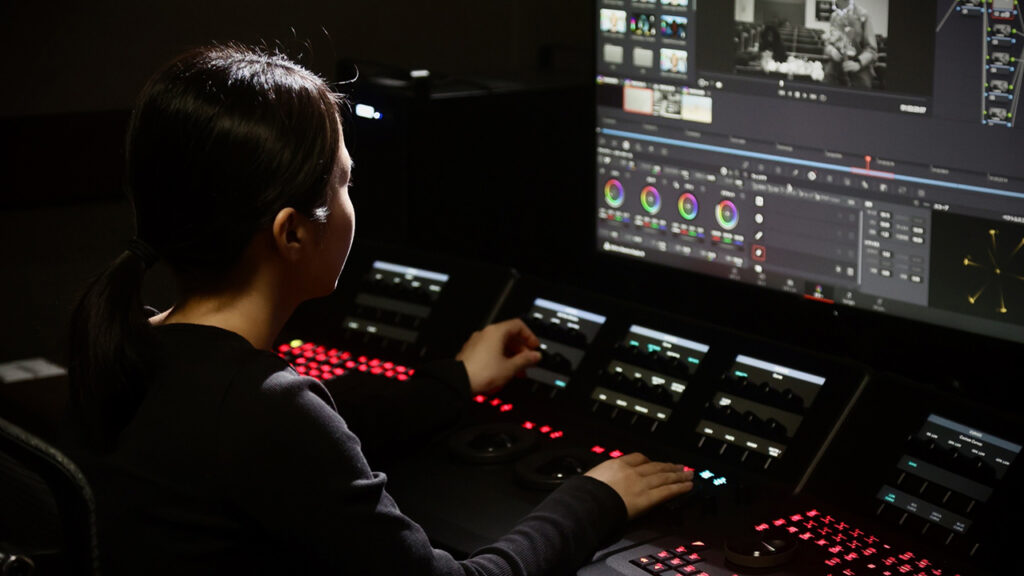 A woman works on a computer in a production studio