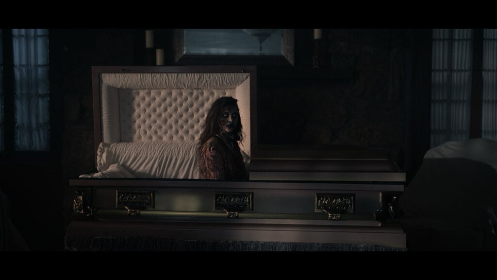 a corpse sits up in a casket