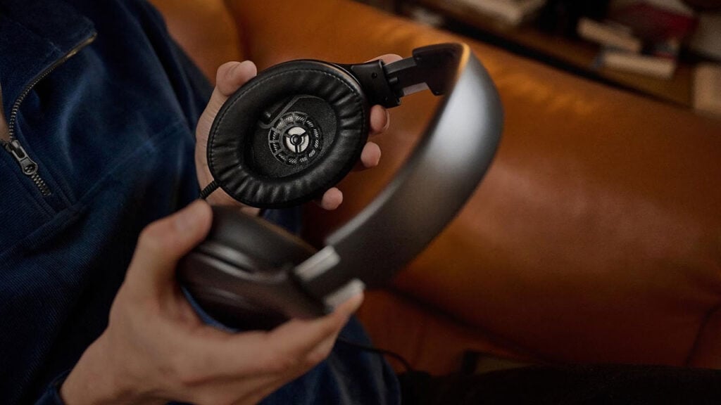 a person holds a set of Sennheiser’s audiophile headphones