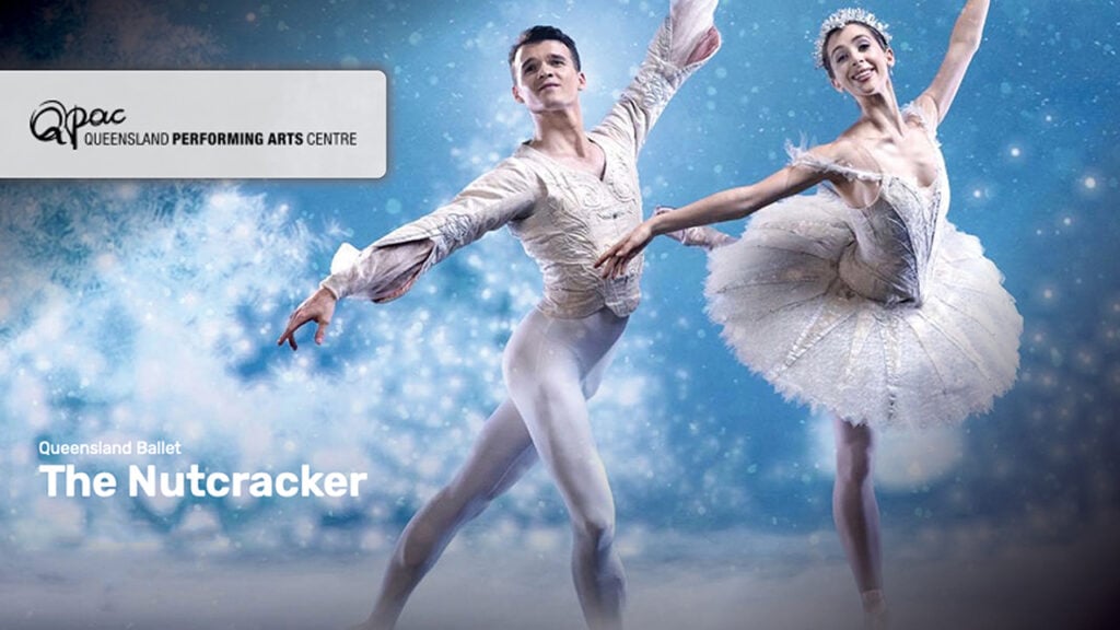 A man and a woman wearing white strike a dancing pose