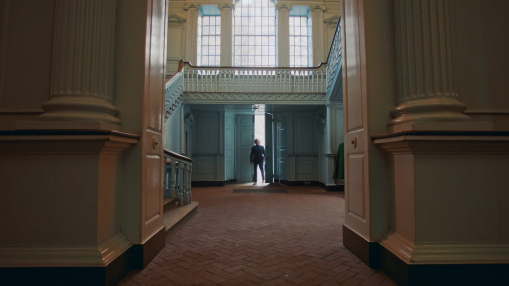 A man walks through the front door of a very large building