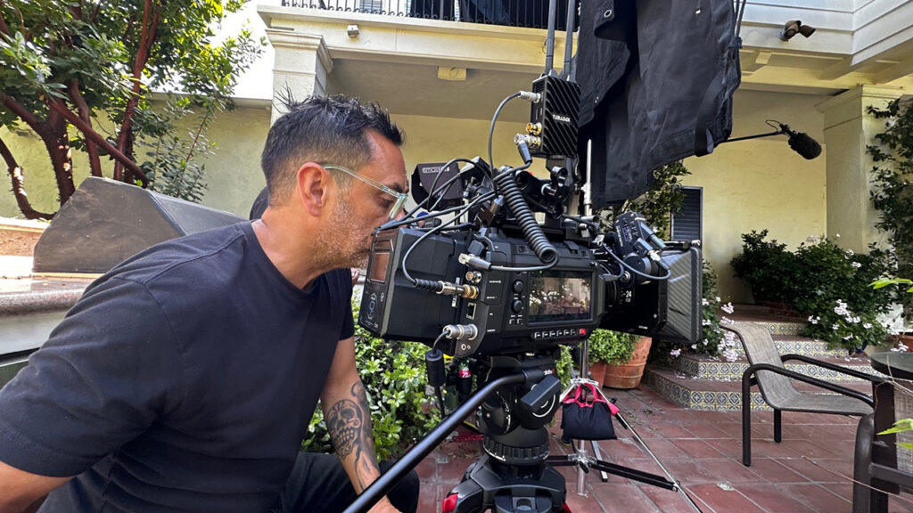 A man looks through the viewfinder of a Blackmagic URSA Cine 12K LF camera
