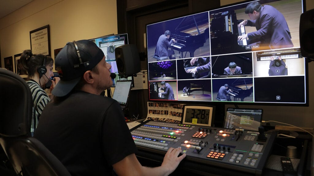 a man runs a broadcast studio filled with equipment and monitors