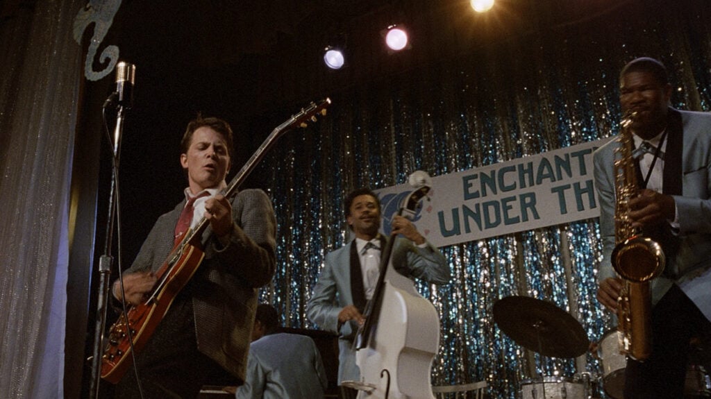 scene from the movie Back to the Future featuring Michael J. Fox playing guitar on a stage