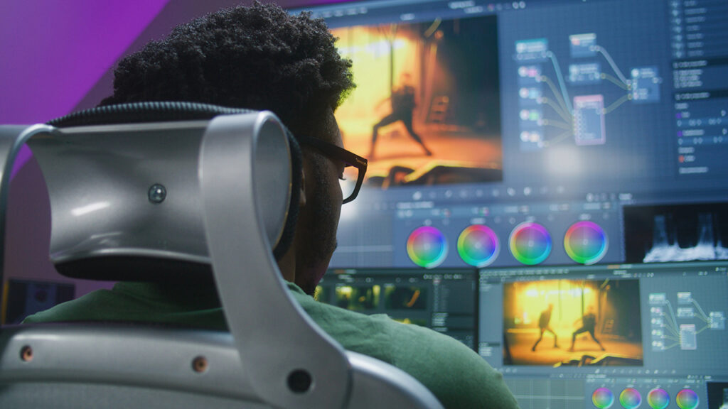 a person edits video in front of a monitor
