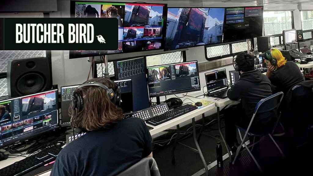 several people work in a broadcast studio behind computers