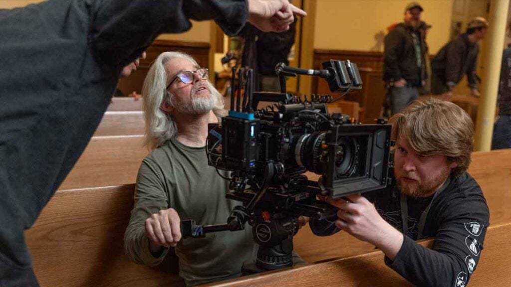 camera operators film from the pews of a church