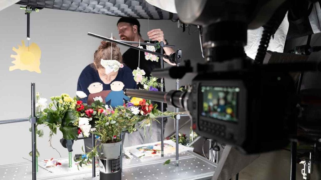 People set up characters on set before a Blackmagic camera