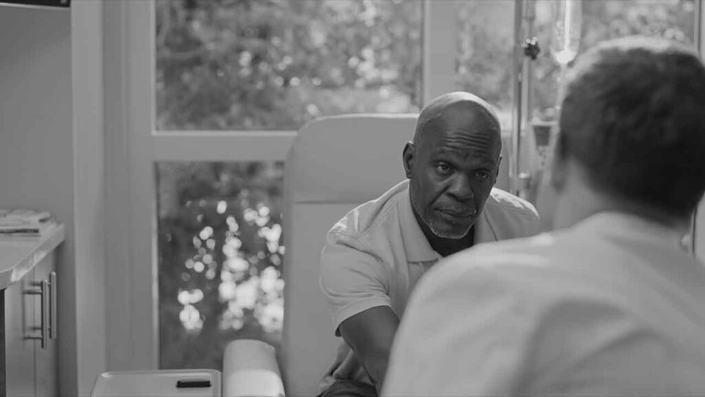 Black and white shot of a man sitting in a chair