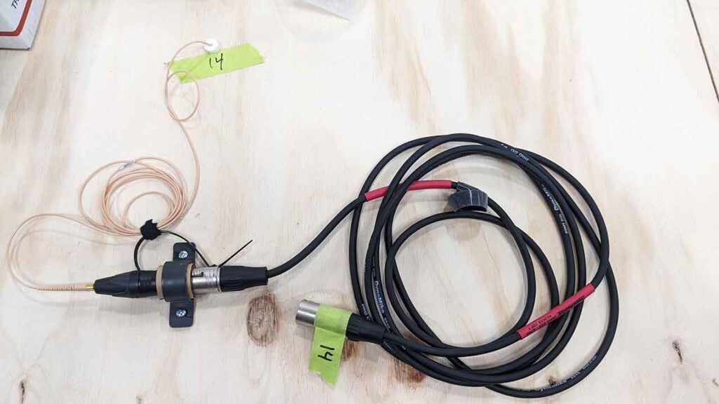 A DPA 6061 subminiature microphone as it is being attached to the bottom of a table in a hidden location
