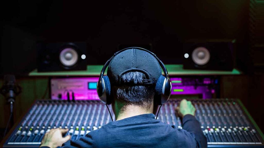 A man mixes music in a recording studio