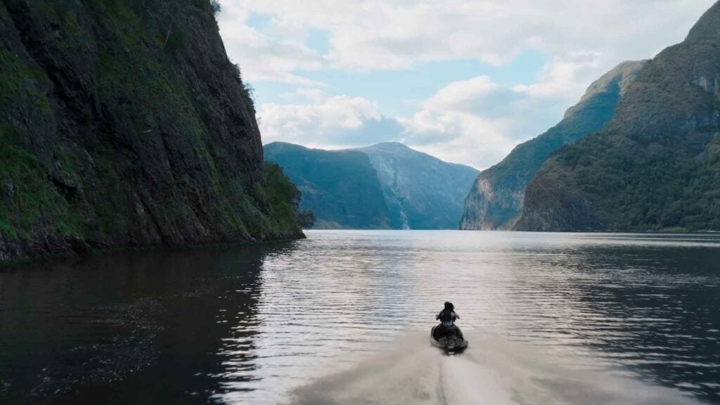a boat navigates through a fjord in Norway