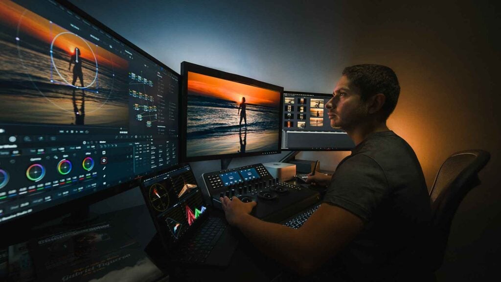 A man on a computer uses DaVinci Resolve software to edit footage