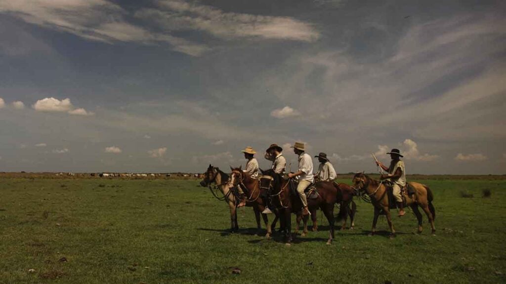 a scene from La Vorágine showing several men sitting on horses