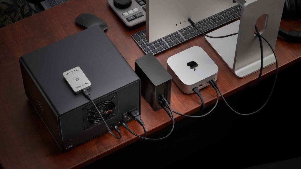 A daisy chain behind a Mac computer containing the OWC Express 4M2