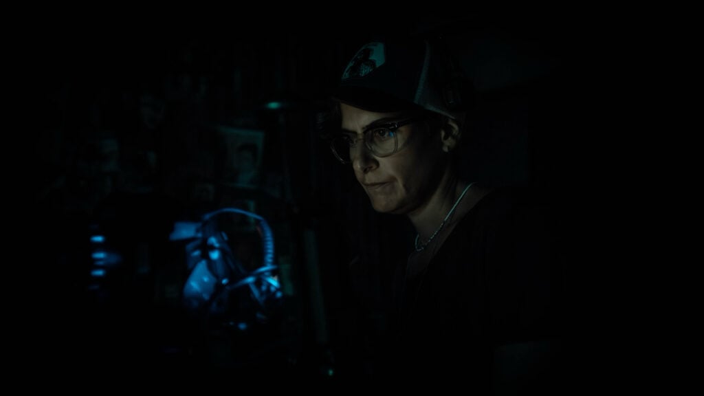a man operates a camera on a dark set