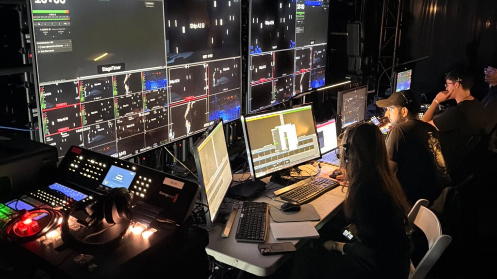 people produce live coverage of an event in a dark studio filled with monitors and Blackmagic Design production equipment and software