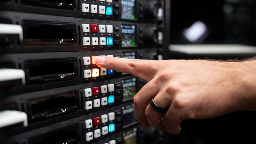 a finger pushes a button on the Blackmagic HyperDeck Studio 4K Pro device