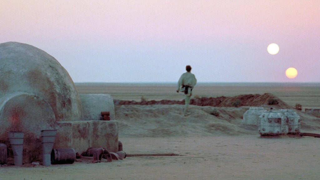 still image of a scene from Star Wars where Luke Skywalker is walking across a desert landscape