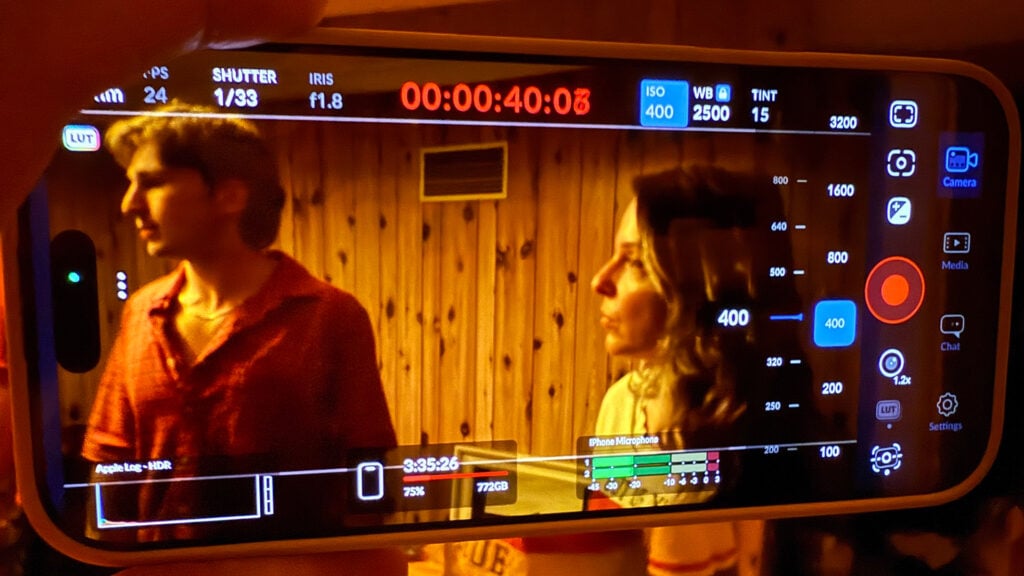 A scene featuring a man and a woman being recorded on an iPhone using Blackmagic Camera App