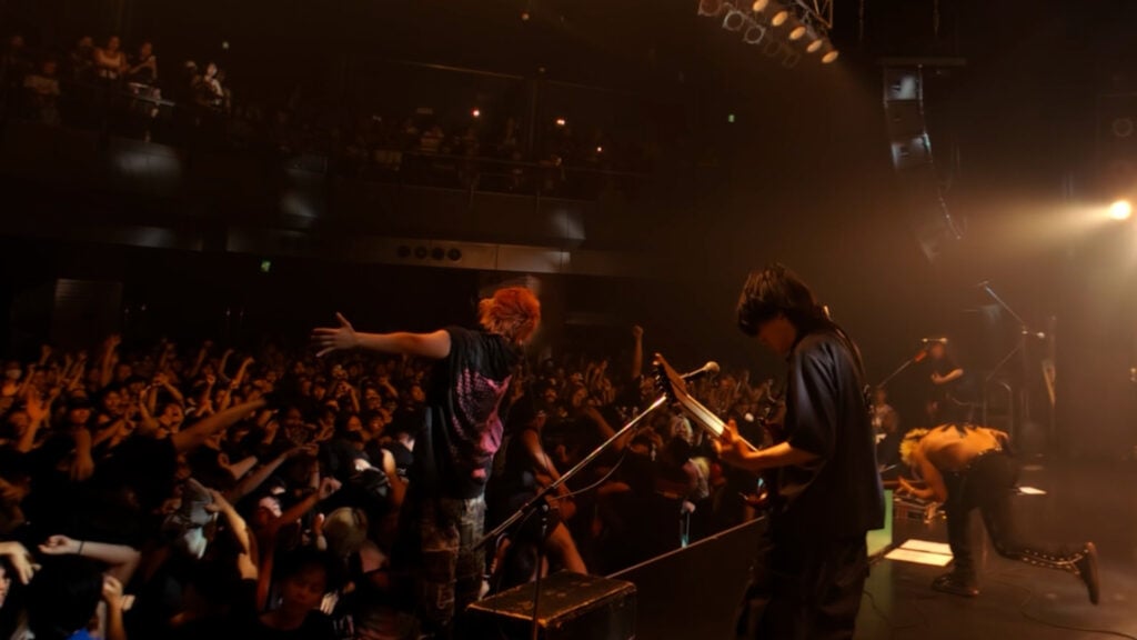 a band performs on stage while a crowd cheers