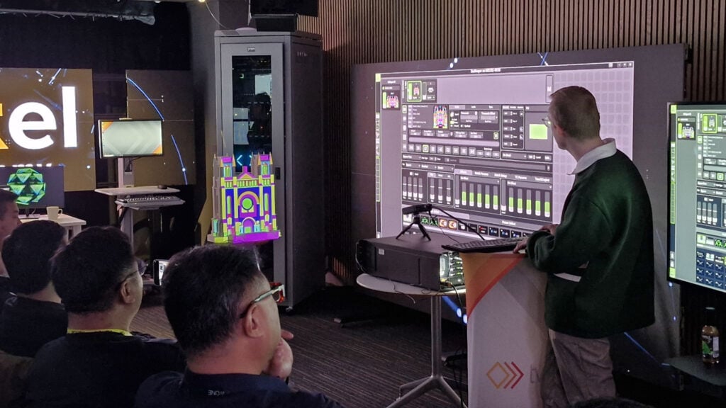 an instructor refers to a large screen that displays software UI during ACT Pixel Academy Green Hippo Training