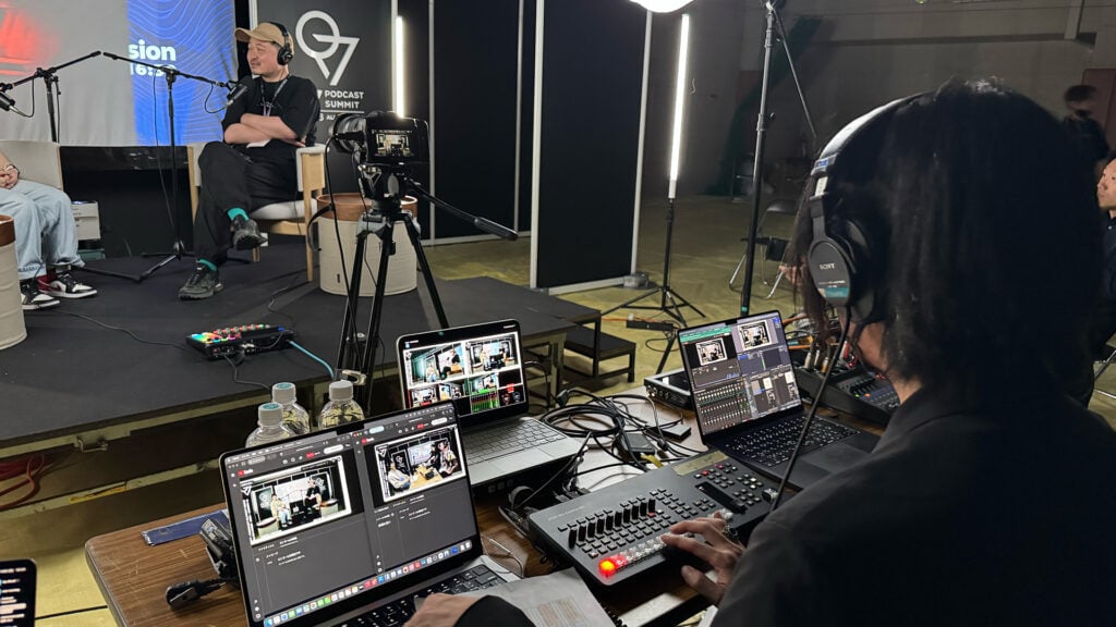 a man sits at a desk and controls the Blackmagic Design equipment that is running his recording of a podcast